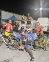 Ice boy workers and friends together at Veld 2024, standing around an Ice Boy-branded vehicle, with bicycles in the foreground.